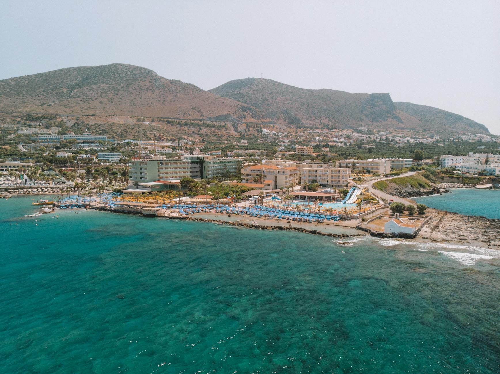 Stunning aerial view of Hersonissos coastline with resorts and Mediterranean Sea in Greece.