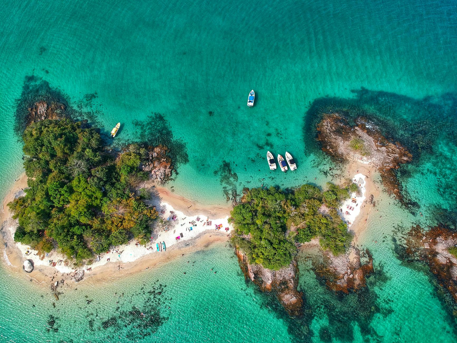 Stunning aerial shot of a tropical island in Angra dos Reis, Brazil with turquoise waters and lush greenery.