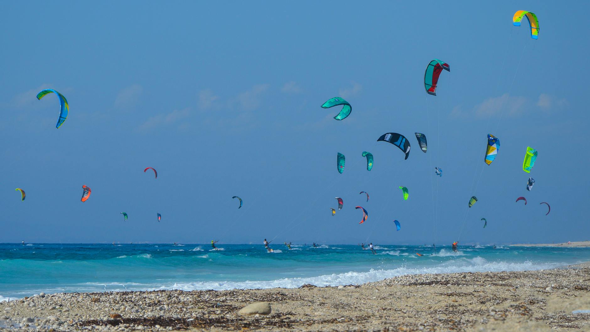 Dynamic scene with multiple kiteboarders in Greece, capturing the essence of adventure and outdoor sports.