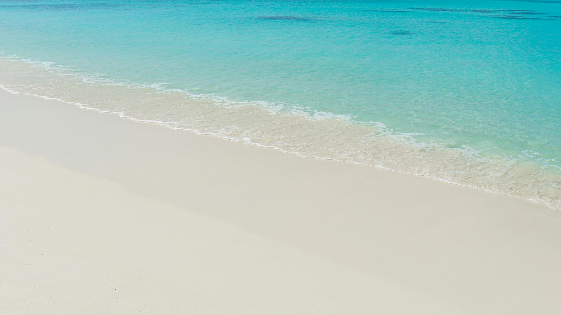 Pristine white sand beach and turquoise waters in the Maldives, exuding tranquility and paradise vibes.