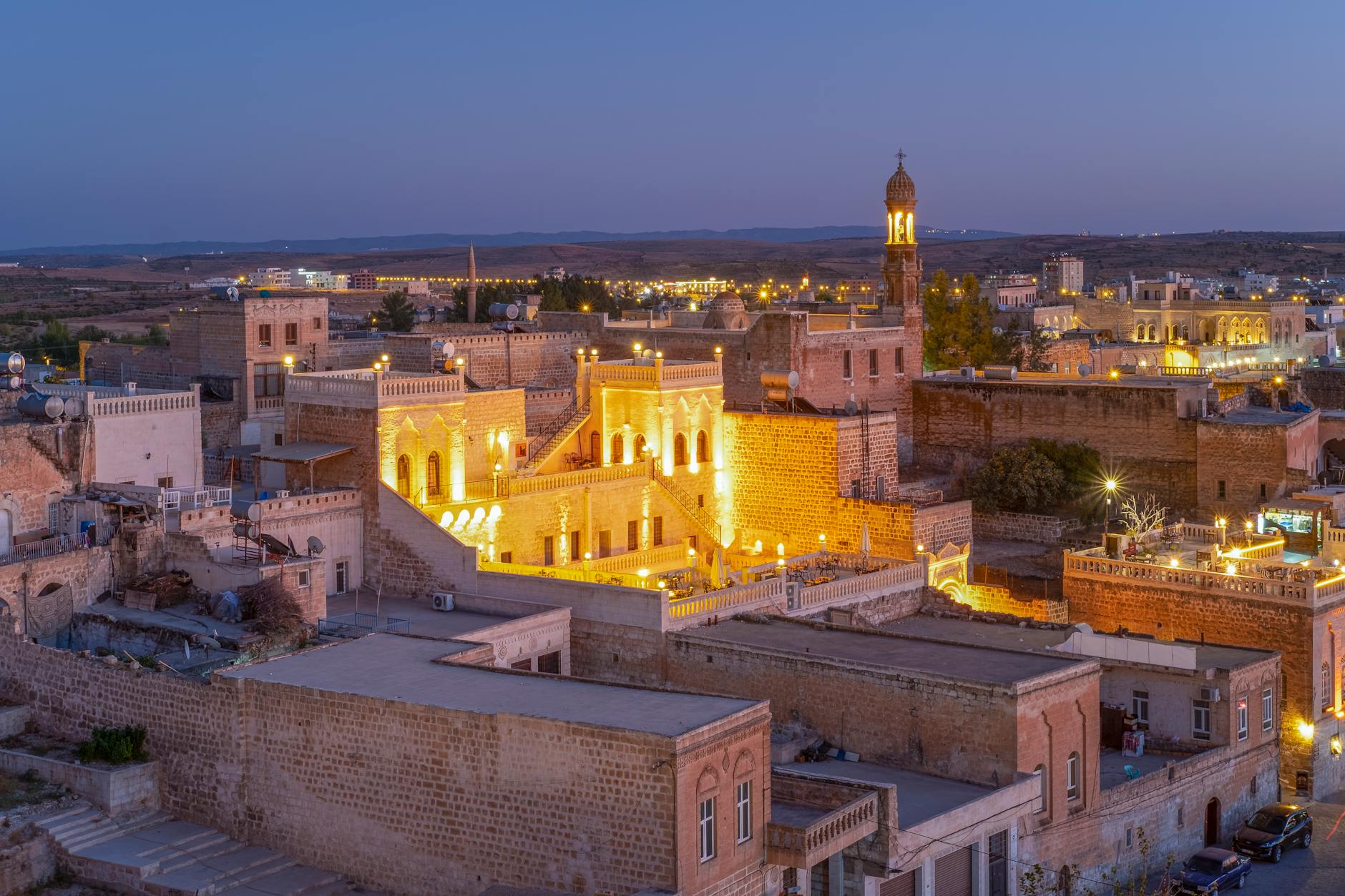 Enchanting aerial view of illuminated Midyat, Mardin, Türkiye, highlighting ancient architecture at night.