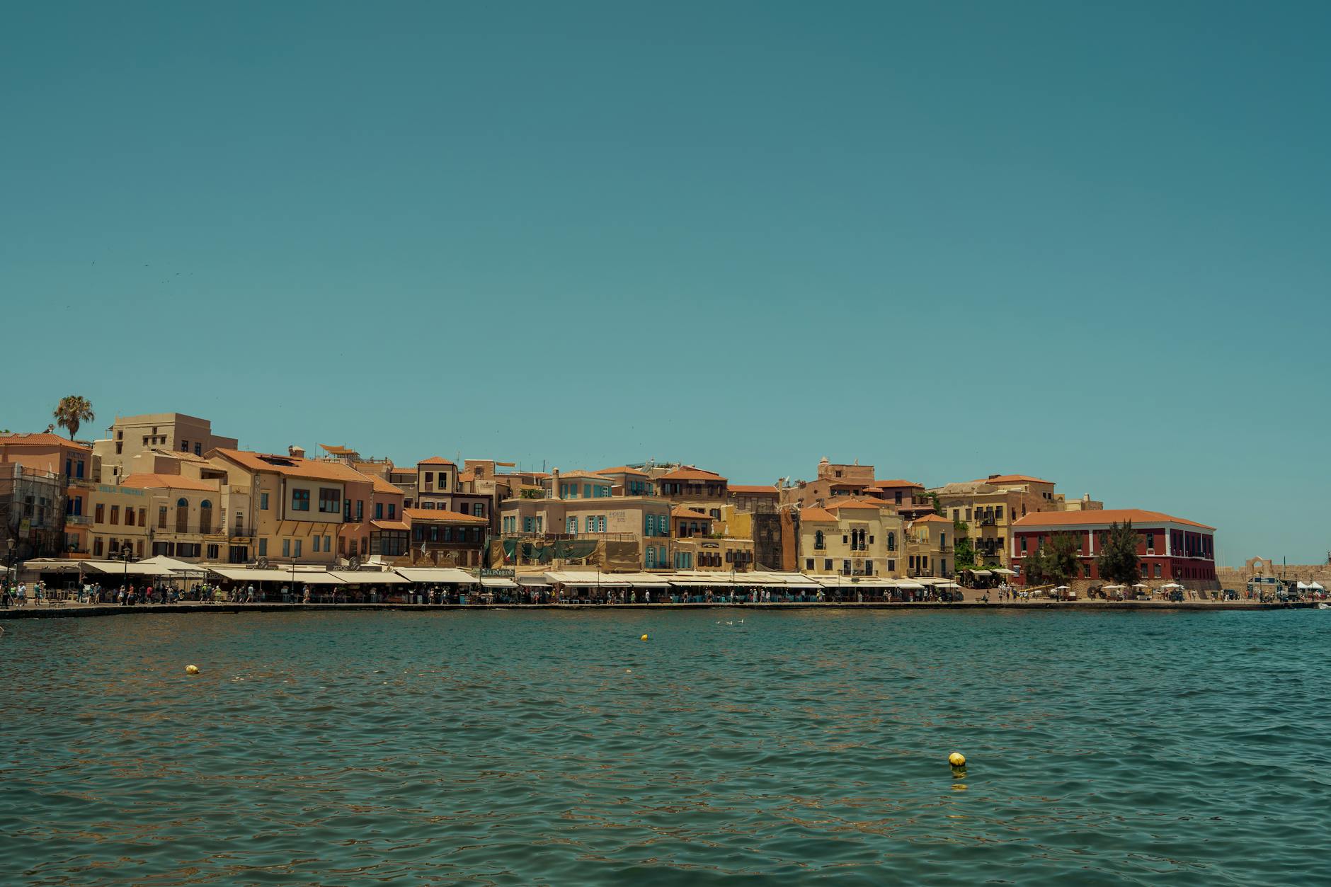 Scenic view of Chania Old Town and harbor, Crete, Greece, under clear blue sky.